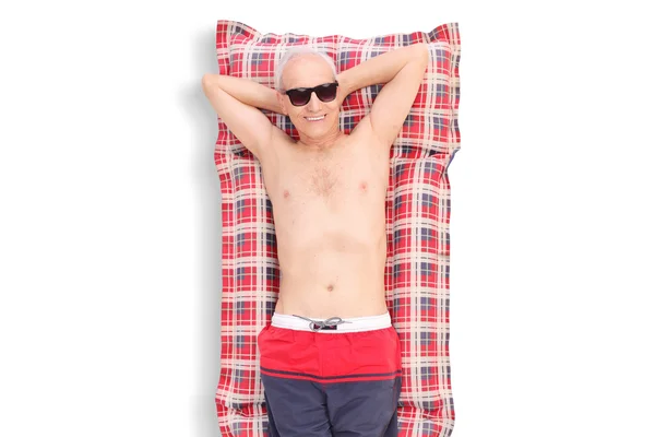Hombre mayor acostado en un colchón de natación —  Fotos de Stock