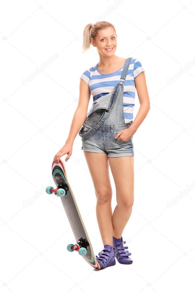 Blond hipster girl posing with a skateboard 