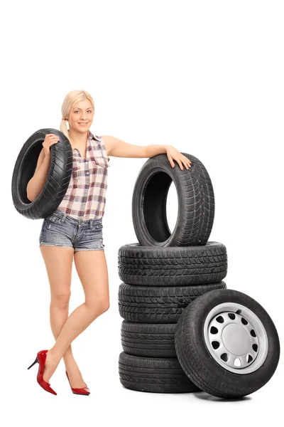 Female mechanic holding a car tire — Stock Photo, Image