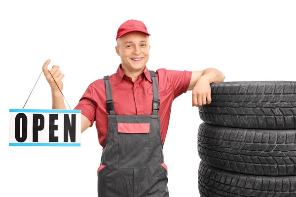 Young mechanic holding an open sign — Stock Photo, Image