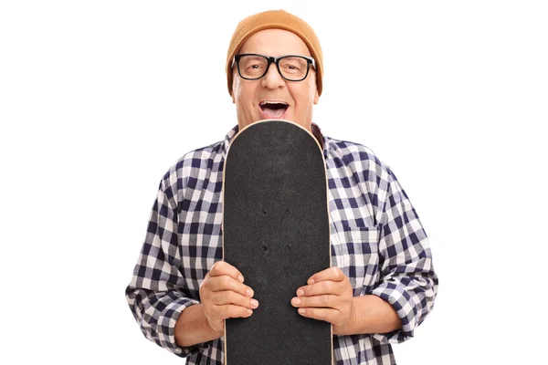 Patinador sênior alegre segurando um skate — Fotografia de Stock