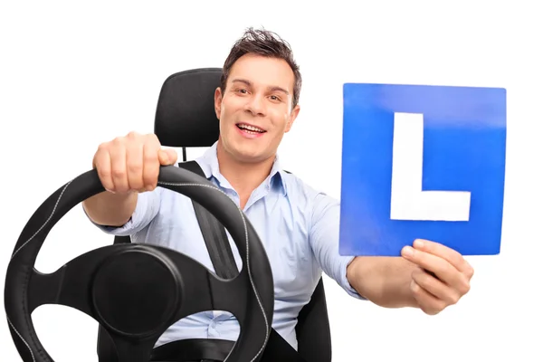 Hombre fingiendo conducir y sosteniendo un letrero en L —  Fotos de Stock
