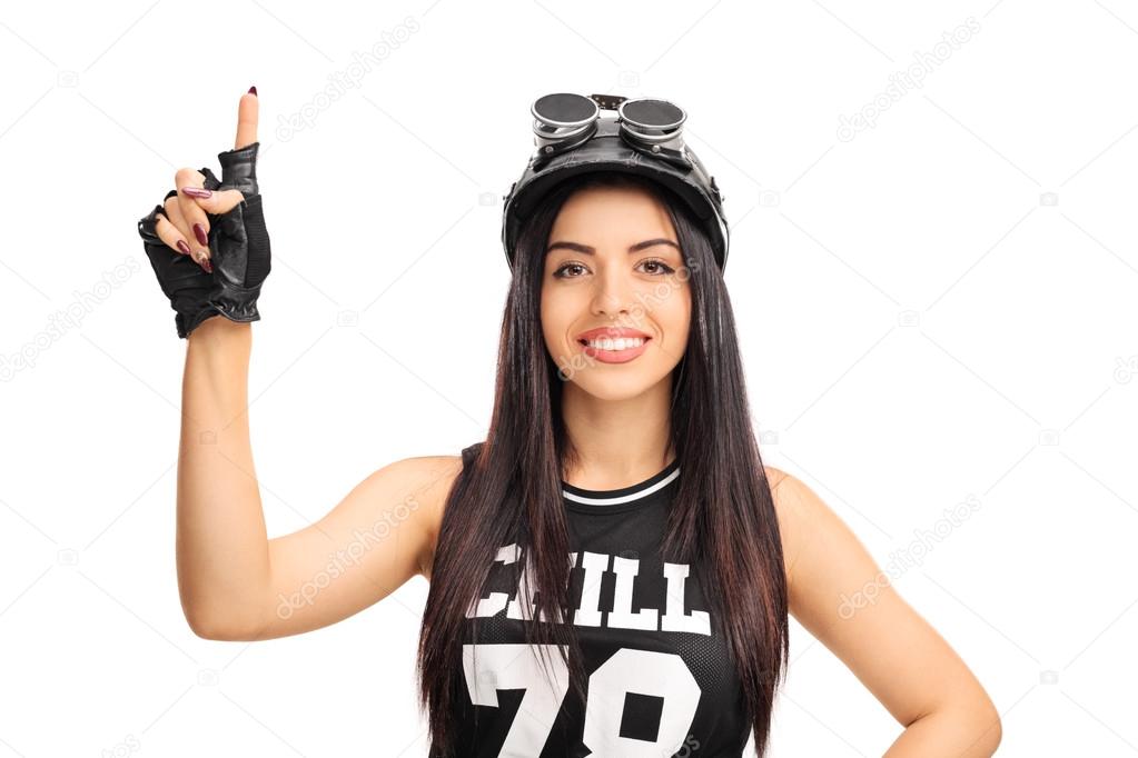 Young female motorcyclist pointing up 