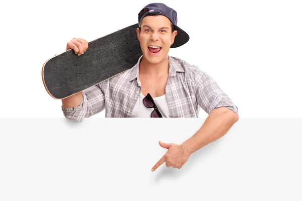 Young skater pointing on a blank signboard — Stock Photo, Image