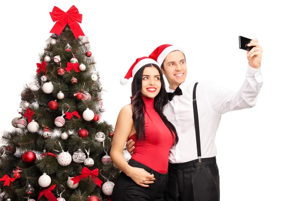 Pareja tomando una selfie junto a un árbol de Navidad — Foto de Stock