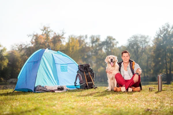 Camper w łące przytulanie psa — Zdjęcie stockowe