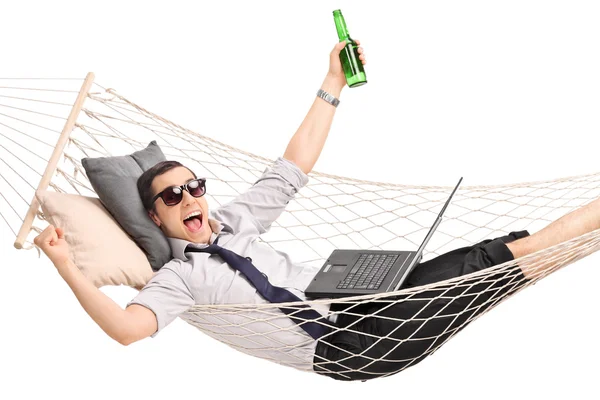 Businessman in a hammock with laptop and beer — Stock Photo, Image