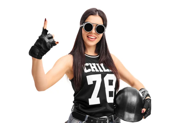 Female biker holding a helmet and pointing up — Stock Photo, Image