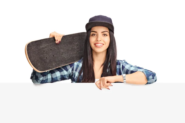 Female skater posing behind a panel — Stock Photo, Image