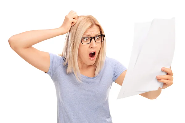 Shocked woman looking at bills in disbelief — Stok fotoğraf