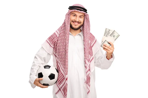 Jovem árabe segurando um futebol e dinheiro — Fotografia de Stock