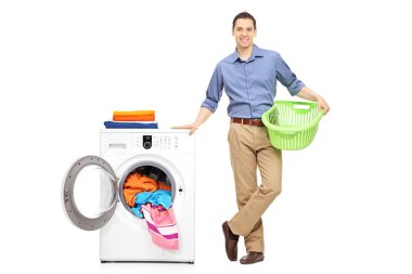 Man with basket next to a washing machine