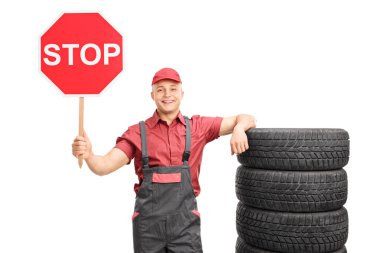 Young mechanic holding a stop sign