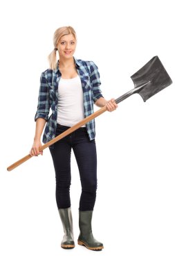 Woman in rubber boots holding a shovel