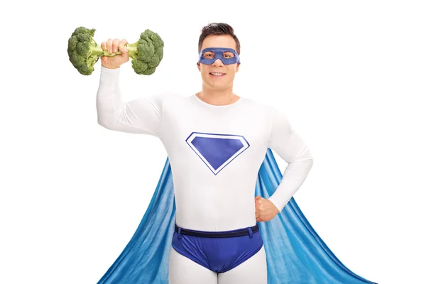 Superhero lifting a broccoli dumbbell — Stockfoto