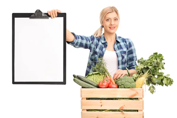 Kvinna med ett urklipp som säljer grönsaker — Stockfoto