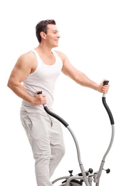 Jeune homme faisant de l'exercice sur un cross trainer — Photo