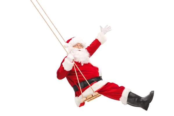 Santa Claus swinging on a wooden swing — Stock Photo, Image