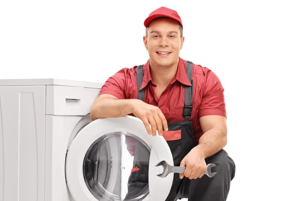 Young cheerful plumber holding a wrench — Stock Photo, Image