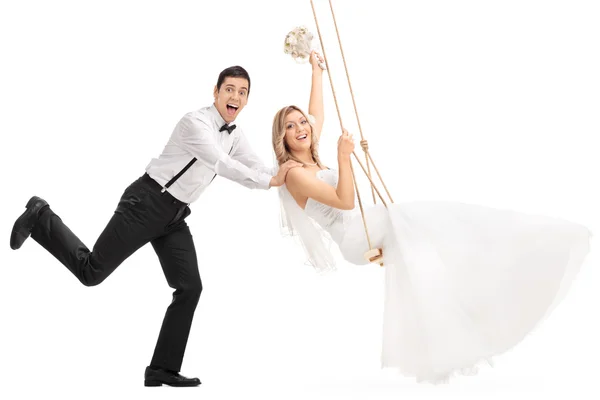 Man pushing his wife on a swing — Stock Photo, Image