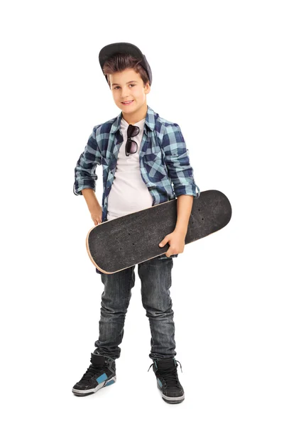 Ragazzino figo che tiene uno skateboard — Foto Stock