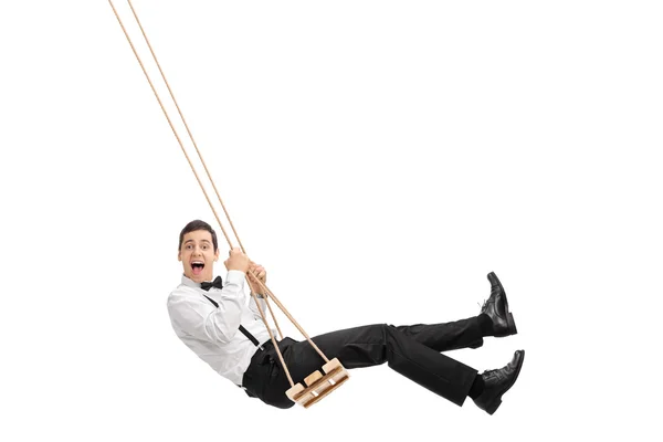 Elegante hombre balanceándose en un columpio de madera — Foto de Stock