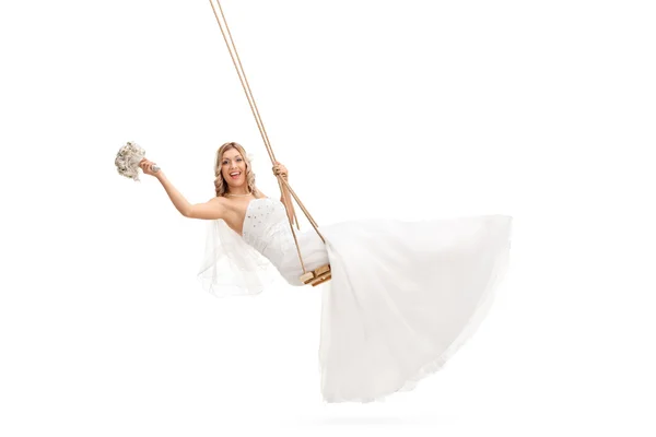 Carefree bride swinging on a wooden swing — Stock Photo, Image