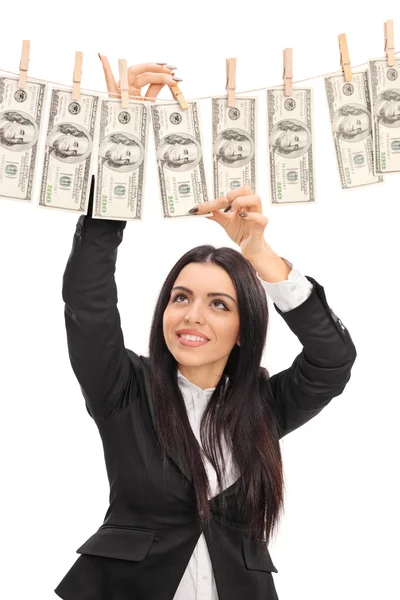 Businesswoman pinning money on a clothesline — Stock Photo, Image