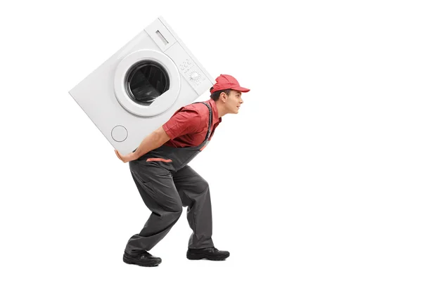 Bir çamaşır makinesi taşıyan işçi — Stok fotoğraf
