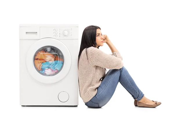 Joven ama de casa esperando la lavandería — Foto de Stock