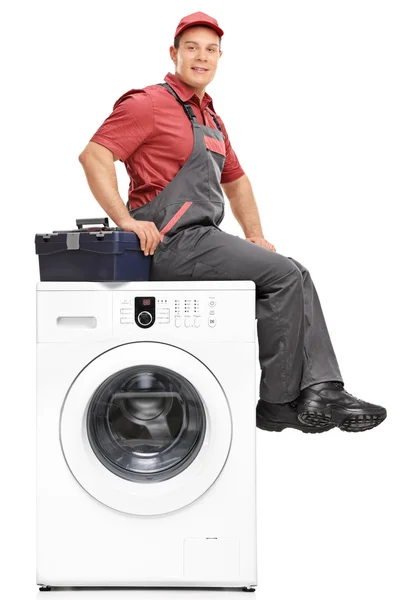 Repairman sitting on top of a washing machine — Stock Photo, Image