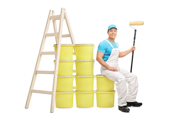 Decorator sitting on a pile of color buckets — Stock Photo, Image