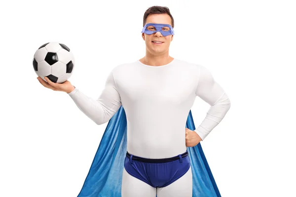 Jeune super-héros masculin tenant un ballon de football — Photo