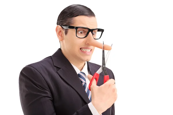 Geschäftsmann schneidet sich die Spitze seiner langen Nase ab — Stockfoto