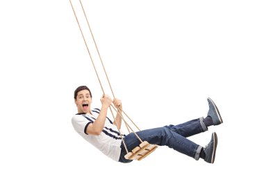 Delighted guy swinging on a wooden swing 