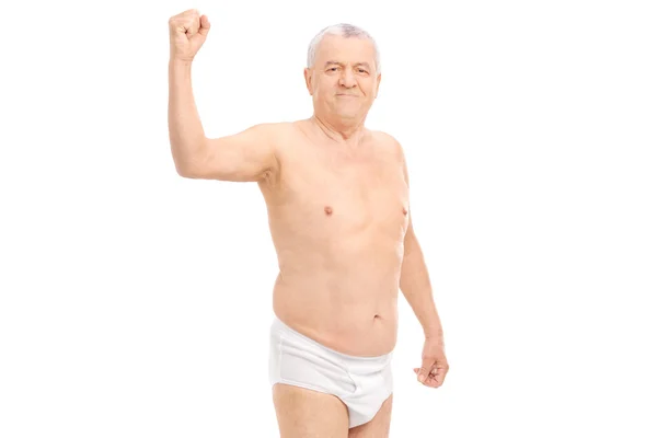 Semi-dressed senior man flexing bicep — Stockfoto