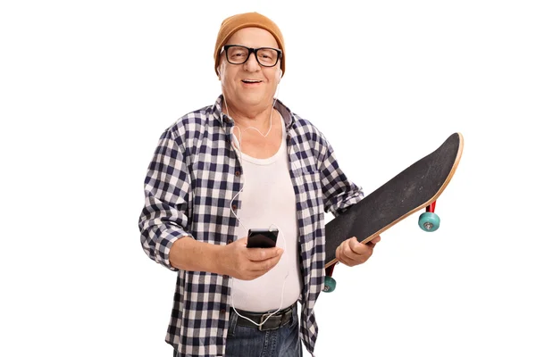 Senior skater listening music on headphones — Stock Photo, Image