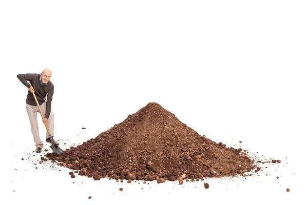 Senior man shoveling a pile of dirt — Stock Photo, Image