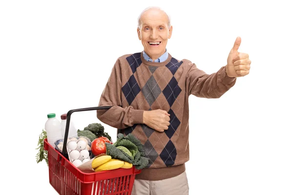 Starší muž s košíkem a dává palec — Stock fotografie