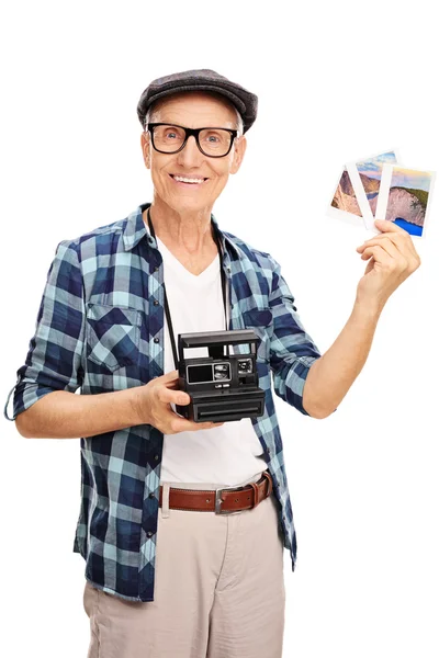 Starší muž s několika fotografiemi a fotoaparát — Stock fotografie