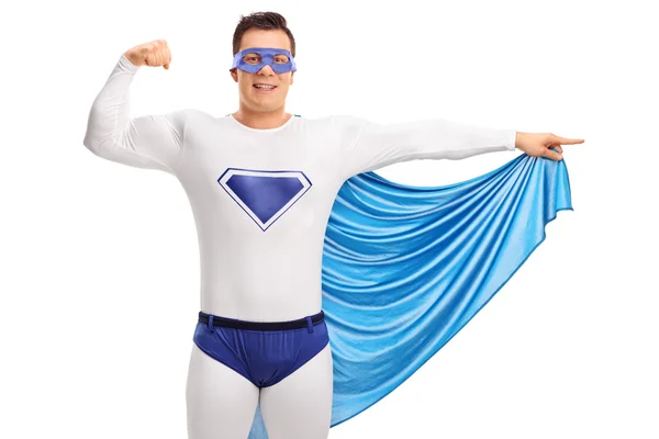 Superhero flexing his bicep and pointing — Stock Photo, Image
