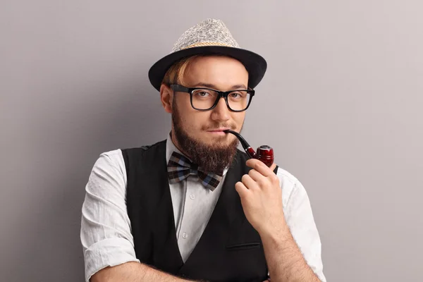 Jovem hipster com fedora fumando um cachimbo — Fotografia de Stock