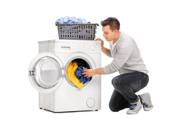 Man putting clothes in a washing machine — Stock Photo, Image