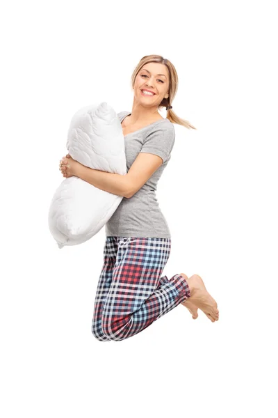 Mujer rubia sosteniendo una almohada y saltando — Foto de Stock