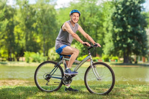 年配の男性が公園で自転車に乗って — ストック写真