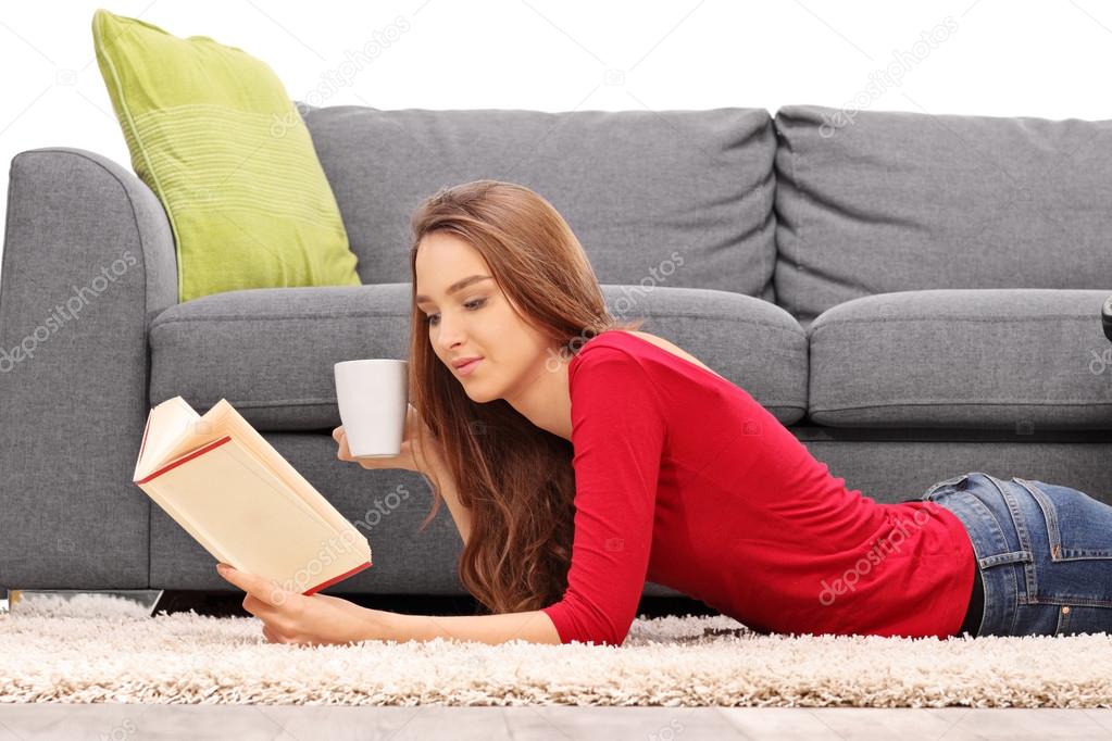 Young woman on the floor reading a book