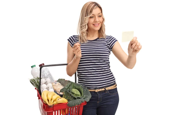 Woman holding a basket and reading a paper — Stock Photo, Image