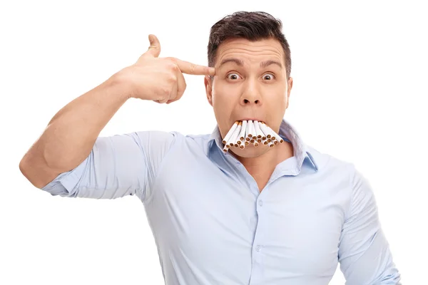 Man with cigarettes holding a hand gun on head — Stockfoto