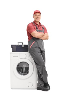 Young repairman leaning on a washing machine  clipart