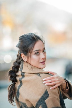 Bir Avrupa şehrinde şapkalı güzel genç bir kadın yürüyor.